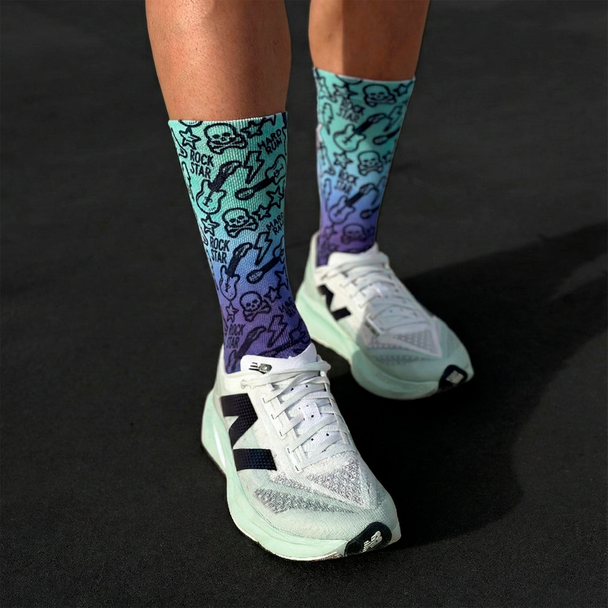 Chaussettes techniques et sans coutures Rock & Run, design dégradé bleu-violet avec imprimé de guitares et de crânes.