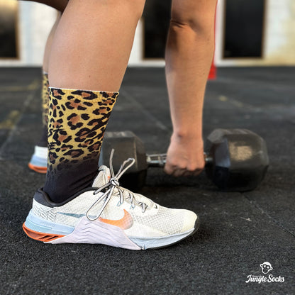 Mujer entrenando con calcetines de deporte JungleSocks Leopardo y Nike Metcon